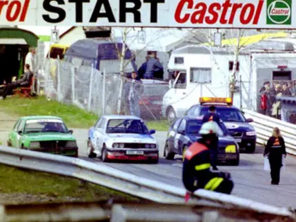 Historisches Foto: Castrol-Startbogen mit Fahrzeugen und Streckenposten